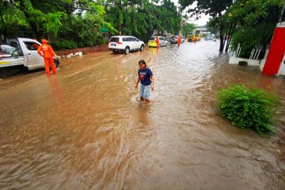 Kendaraan melintasi genangan air akibat hujan deras di Jalan Raya Kebayoran Lama, Jakarta Selatan, Minggu (7/11/2021).