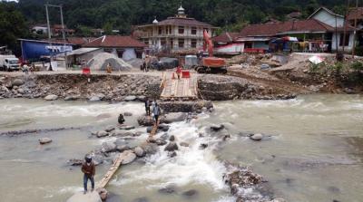Foto udara saat warga melintasi sungai Ciberang melalui jembatan darurat yang putus akibat derasnya air sungai di Kampung Muhara, Kabupaten Lebak.