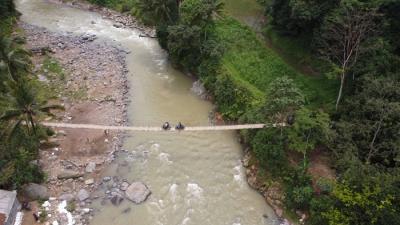 Foto udara saat warga melintasi sungai Ciberang melalui jembatan darurat yang putus akibat derasnya air sungai di Kampung Muhara, Kabupaten Lebak.