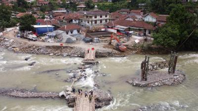 Foto udara saat warga melintasi sungai Ciberang melalui jembatan darurat yang putus akibat derasnya air sungai di Kampung Muhara, Kabupaten Lebak.