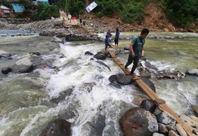 Foto udara saat warga melintasi sungai Ciberang melalui jembatan darurat yang putus akibat derasnya air sungai di Kampung Muhara, Kabupaten Lebak.