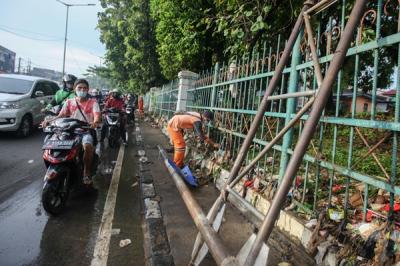 Polisi mengatur lalu lintas dekat tanggul Kali Baru yang jebol akibat luapan air di kawasan Hek, Kramat Jati, Jakarta Timur, Senin (8/11/2021).