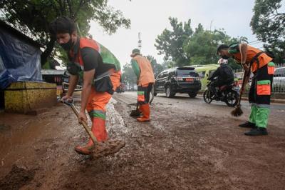 Polisi mengatur lalu lintas dekat tanggul Kali Baru yang jebol akibat luapan air di kawasan Hek, Kramat Jati, Jakarta Timur, Senin (8/11/2021).