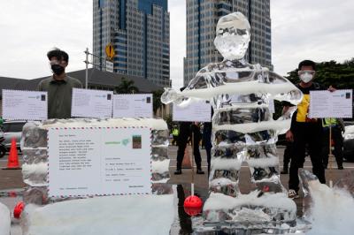 Relawan Greenpeace saat menggelar aksi 1.000 kartu pos rakyat untuk Presiden Joko Widodo di kawasan Patung Kuda, Jakarta Pusat, Rabu (10/11/2021).