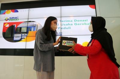 Ketua MNC Peduli Jessica Tanoesoedibjo (kiri) memberikan bantuan gerobak secara simbolis kepada ibu Tia di Jakarta, Kamis (11/11/2021).
