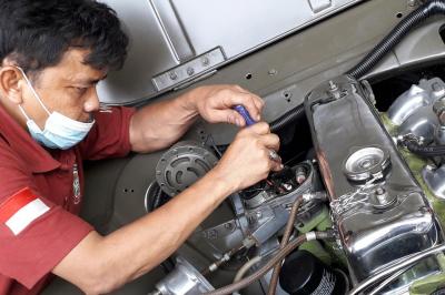 Pitono tengah memperbaiki mobil Jeep.