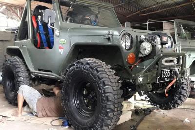 Pitono tengah memperbaiki mobil Jeep.