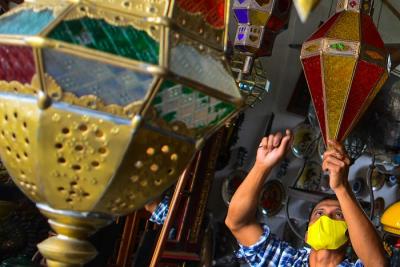Andi (34) pedagang Lampion Antik membersihkan barang dagangannya di Kawasan Cilegon, Banten, Jumat (12/11/2021).
