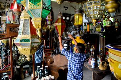 Andi (34) pedagang Lampion Antik membersihkan barang dagangannya di Kawasan Cilegon, Banten, Jumat (12/11/2021).