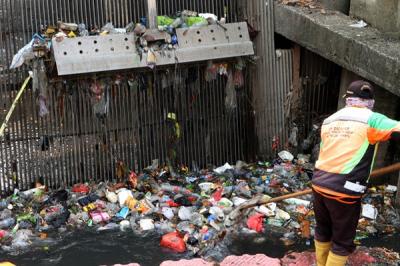 Pekerja membersihkan sampah plastik dan ranting pohon dialiran kali Item, Jakarta, Sabtu (13/11/2021).