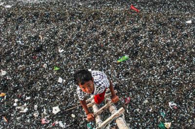 Warga membuang limbah kerang hijau di tepi laut Cilincing, Jakarta Utara, Selasa (16/11/2021).