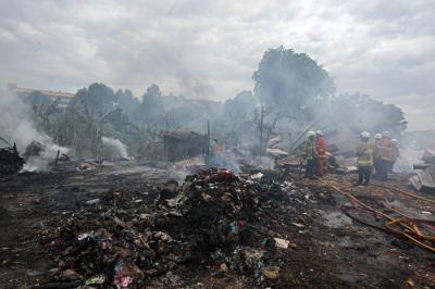 Petugas Pemadam Kebakaran melakukan pendinginan api kebakaran pabrik penggilingan kapas di Pasar Rebo, Jakarta Timur, Selasa (16/11/2021).