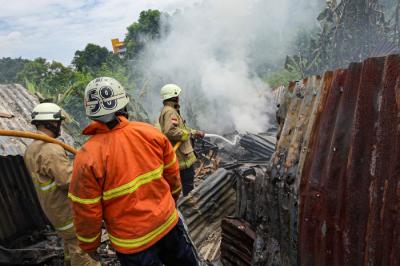 Petugas Pemadam Kebakaran melakukan pendinginan api kebakaran pabrik penggilingan kapas di Pasar Rebo, Jakarta Timur, Selasa (16/11/2021).