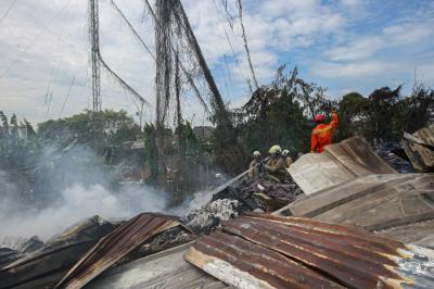 Petugas Pemadam Kebakaran melakukan pendinginan api kebakaran pabrik penggilingan kapas di Pasar Rebo, Jakarta Timur, Selasa (16/11/2021).