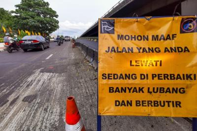 Kendaraan saat melintasi jalan yang sedang dalam proses perbaikan di Jalan Gatot Subroto, Jakarta, Rabu (17/11/2021).