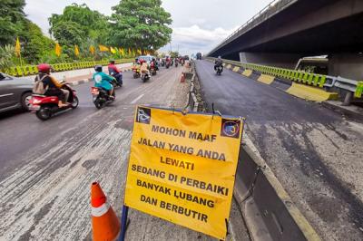 Kendaraan saat melintasi jalan yang sedang dalam proses perbaikan di Jalan Gatot Subroto, Jakarta, Rabu (17/11/2021).