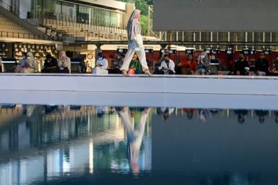Model memperagakan busana muslim dalam acara Embracing Jakarta Muslim Fashion Week di Aquatic Center, Gelora Bung Karno, Senayan, Jakarta, Kamis (18/11/2021).