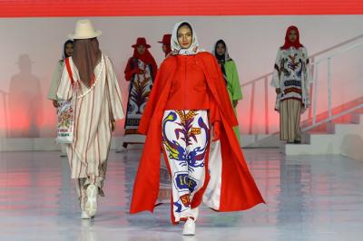 Model memperagakan busana muslim dalam acara Embracing Jakarta Muslim Fashion Week di Aquatic Center, Gelora Bung Karno, Senayan, Jakarta, Kamis (18/11/2021).