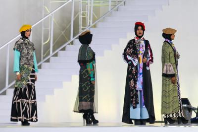 Model memperagakan busana muslim dalam acara Embracing Jakarta Muslim Fashion Week di Aquatic Center, Gelora Bung Karno, Senayan, Jakarta, Kamis (18/11/2021).
