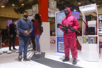 Petugas Stand Pertamina mengenakan kostum Squid Game dalam ajang GIIAS 2021 di Indonesia Convention Exhibition (ICE) BSD, Jumat (19/11/2021).