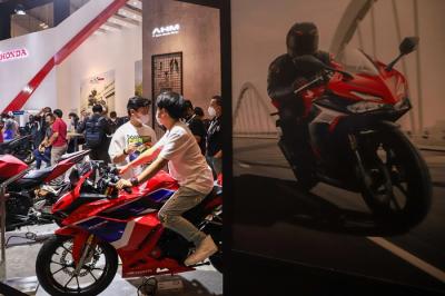 Pengunjung melihat motor yang dipamerkan selama pameran otomotif GIIAS 2021 di Indonesia Convention Exhibition (ICE) BSD, Jumat (19/11/2021).