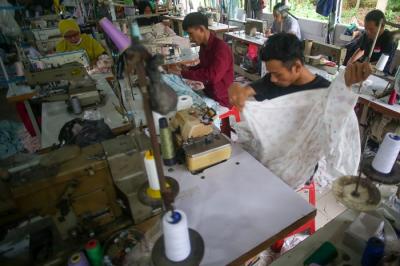 Pekerja menyelesaikan pembuatan baju di sebuah konveksi milik Nca di Curug, Bogor, Jumat (19/11/2021).