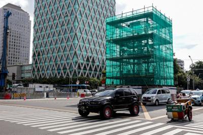 Kendaraan melintas di dekat proyek relokasi Tugu Jam di Jalan M.H Thamrin, Jakarta Pusat, Senin (22/11/2021).