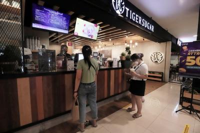 Karyawan merapikan menu makanan di salah satu cafe di Jakarta, Selasa (23/11/2021).