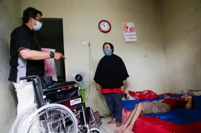 Head of CSR MNC Group Tengku Havid (kiri) berbincang dengan Daronah yang merupakan orang tua dari Slamet (21) saat penyerahan bantuan dari MNC Peduli.