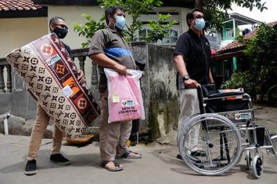 Head of CSR MNC Group Tengku Havid (kiri) berbincang dengan Daronah yang merupakan orang tua dari Slamet (21) saat penyerahan bantuan dari MNC Peduli.