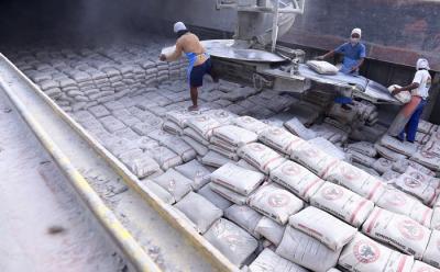 Pekerja memindahkan karung semen ke atas kapal di dermaga Semen Padang, Teluk Bayur, Padang, Sumatera Barat, Rabu (24/11/2021).