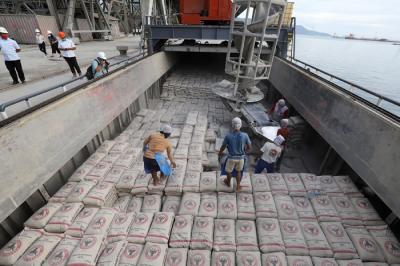 Pekerja memindahkan karung semen ke atas kapal di dermaga Semen Padang, Teluk Bayur, Padang, Sumatera Barat, Rabu (24/11/2021).