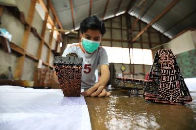 Perajin menjemur batik di rumah produksi batik tanah liek Ayesha di Padang, Sumatera Barat, Jumat (26/11/2021).