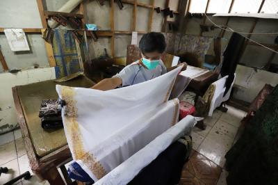 Perajin menjemur batik di rumah produksi batik tanah liek Ayesha di Padang, Sumatera Barat, Jumat (26/11/2021).