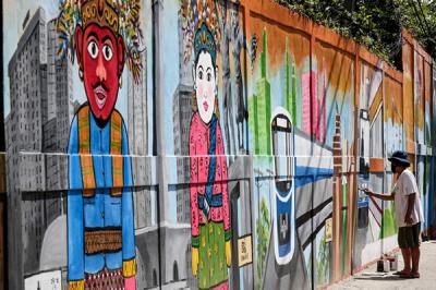 Petugas PPSU menyelesaikan pembuatan mural bertema 'Kota Jakarta' di kawasan Tanah Kusir, Kebaroyan Lama, Jakarta Selatan, Jumat (26/11/2021).