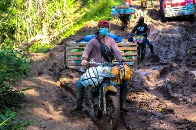 Para tukang ojek seko berusaha mengendalikan sepeda motor yang dipenuhi barang bawaan di Kecamatan Seko, Kabupaten Luwu Utara, Sulawesi Selatan.