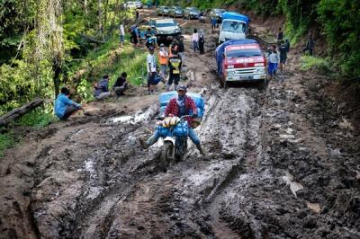 Para tukang ojek seko berusaha mengendalikan sepeda motor yang dipenuhi barang bawaan di Kecamatan Seko, Kabupaten Luwu Utara, Sulawesi Selatan.