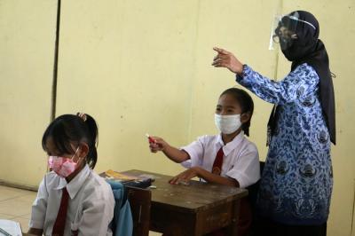 Tenaga pendidik Sekolah Dasar Negeri 01 Pagi Pulau Panggang Provinsi DKI Jakarta menggunakan seragam korpri dalam mengajar pertemuan tatap muka (PTM).