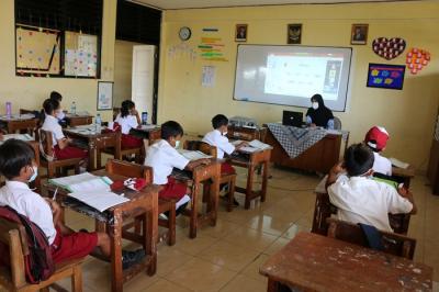 Tenaga pendidik Sekolah Dasar Negeri 01 Pagi Pulau Panggang Provinsi DKI Jakarta menggunakan seragam korpri dalam mengajar pertemuan tatap muka (PTM).