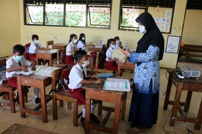 Tenaga pendidik Sekolah Dasar Negeri 01 Pagi Pulau Panggang Provinsi DKI Jakarta menggunakan seragam korpri dalam mengajar pertemuan tatap muka (PTM).