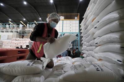 Pekerja menata beras di gudang Bulog di Jakarta.