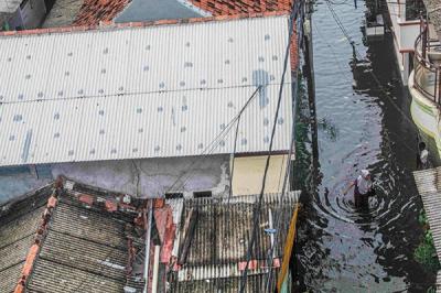 Warga beraktivitas saat banjir rob mengenangi rumahnya di Jalan Lodan Raya, Ancol, Jakarta Utara, Sabtu (4/11/2021).