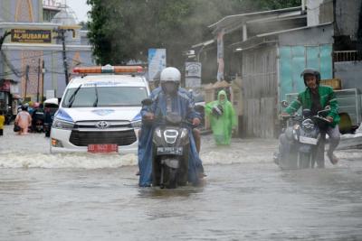 Sejumlah kendaraan menerobos genangan air di Jalan Pacerakkang, Makassar, Senin (6/12/2021).