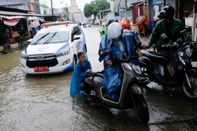 Sejumlah kendaraan menerobos genangan air di Jalan Pacerakkang, Makassar, Senin (6/12/2021).