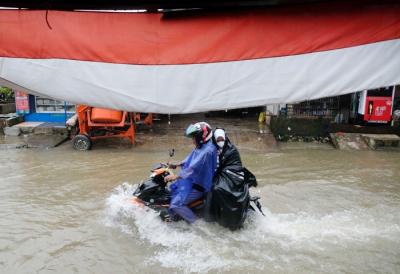 Sejumlah kendaraan menerobos genangan air di Jalan Pacerakkang, Makassar, Senin (6/12/2021).