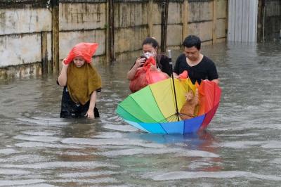Sejumlah warga melewati banjir untuk mengungsi ketempat yang lebih aman di Makassar, Selasa (7/12/2021).
