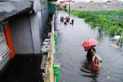 Sejumlah warga melewati banjir untuk mengungsi ketempat yang lebih aman di Makassar, Selasa (7/12/2021).