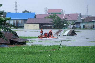 Sejumlah warga melewati banjir untuk mengungsi ketempat yang lebih aman di Makassar, Selasa (7/12/2021).