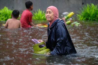Sejumlah warga melewati banjir untuk mengungsi ketempat yang lebih aman di Makassar, Selasa (7/12/2021).