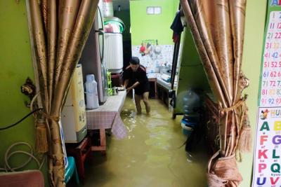 Sejumlah warga melewati banjir untuk mengungsi ketempat yang lebih aman di Makassar, Selasa (7/12/2021).